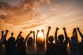 Multi-ethnic people raise their fists up in the air. autumn sunset background