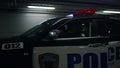 Policemen sitting in patrol car at underground parking. Strict cops aiming guns