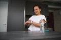 Multi ethnic smiling heathy young woman 40s, checking smart wrist watch. A bottle of pure water on the foreground Royalty Free Stock Photo