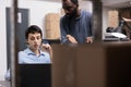 Multi ethnic storehouse workers checking delivery report analyzing transportation stock on laptop computer Royalty Free Stock Photo