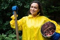 Multi-ethnic woman gardener agronomist with a metal bucket full of harvested crop of dug potatoes in an organic eco farm