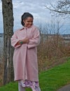 Multi_Ethnic Woman Playful Outside With Pink Coat