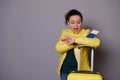 Multi-ethnic woman in yellow jacket, checks time on her wrist watch, feeling anxious being unpunctual at her flight