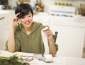 Multi-ethnic Young Woman Smiling Over Financial Calculations Royalty Free Stock Photo