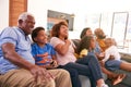 Multi-Generation African American Family Relaxing At Home Sitting On Sofa Watching TV Together Royalty Free Stock Photo