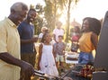 Multi generation black family barbecue, grandad grilling Royalty Free Stock Photo