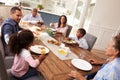 Multi generation black family serving a meal in the kitchen Royalty Free Stock Photo