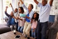 Multi generation black family watching sport on TV celebrate Royalty Free Stock Photo