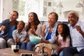 Multi generation black family watching sport on TV at home