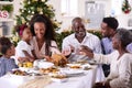 Multi-Generation Family Celebrating Christmas At Home Eating Meal And Making Toast With Water Royalty Free Stock Photo