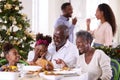 Multi-Generation Family Celebrating Christmas At Home Eating Meal And Making Toast With Water Royalty Free Stock Photo