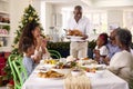 Multi-Generation Family Celebrating Christmas At Home With Grandfather Serving Turkey
