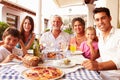 Multi Generation Family Eating Meal At Outdoor Restaurant