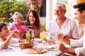 Multi Generation Family Eating Meal At Outdoor Restaurant