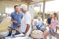 Multi Generation Family Enjoying Cooking Barbecue At Home