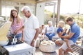 Multi Generation Family Enjoying Cooking Barbecue At Home