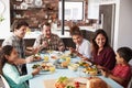 Multi Generation Family Enjoying Meal Around Table At Home Together Royalty Free Stock Photo