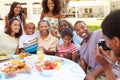 Multi Generation Family Enjoying Meal In Garden Together Royalty Free Stock Photo