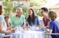 Multi Generation Family Enjoying Outdoor Meal Together Royalty Free Stock Photo