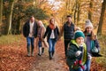 Multi-Generation Family Enjoying Walk Along Autumn Woodland Path Together