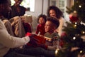 Multi-Generation Family Exchanging And Opening Gifts Around Christmas Tree At Home Royalty Free Stock Photo