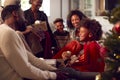 Multi-Generation Family Exchanging And Opening Gifts Around Christmas Tree At Home Royalty Free Stock Photo