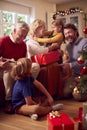 Multi-Generation Family Exchanging And Opening Gifts Around Christmas Tree At Home Royalty Free Stock Photo