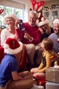 Multi-Generation Family Exchanging And Opening Gifts Around Christmas Tree At Home Royalty Free Stock Photo