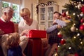 Multi-Generation Family Exchanging And Opening Gifts Around Christmas Tree At Home Royalty Free Stock Photo