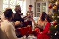 Multi-Generation Family Exchanging And Opening Gifts Around Christmas Tree At Home Royalty Free Stock Photo