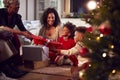 Multi-Generation Family Exchanging And Opening Gifts Around Christmas Tree At Home Royalty Free Stock Photo