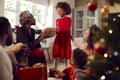 Multi-Generation Family Exchanging And Opening Gifts Around Christmas Tree At Home Royalty Free Stock Photo