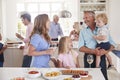 Multi-Generation Family And Friends Gathering In Kitchen For Celebration Party Royalty Free Stock Photo