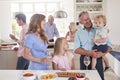 Multi-Generation Family And Friends Gathering In Kitchen For Celebration Party Royalty Free Stock Photo