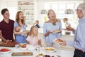 Multi-Generation Family And Friends Gathering In Kitchen For Celebration Party Royalty Free Stock Photo