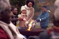 Multi-Generation Family Having Fun Toasting Marshmallows In Autumn Garden Together Royalty Free Stock Photo