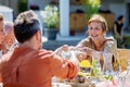 Multi generation family having garden party celebration, grandmother giving salad to her son.