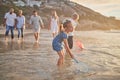 Multi generation family holding hands and walking along the beach together. Caucasian family with two children, two Royalty Free Stock Photo