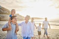 Multi generation family holding hands and walking along the beach together. Caucasian family with two children, two Royalty Free Stock Photo