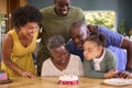 Multi-Generation Family With Military Father Celebrating Birthday With Cake Ay Home