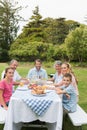 Multi generation family at picnic table having dinner outside Royalty Free Stock Photo