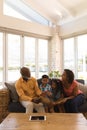 Multi-generation family reading a story book in living room