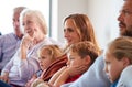 Multi-Generation Family Relaxing At Home Sitting On Sofa Watching Television Together Royalty Free Stock Photo