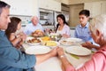 Multi-Generation Family Saying Prayer Before Eating Meal