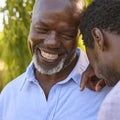 Multi-Generation Family With Senior Father And Adult Song Standing And Laughing In Garden Together