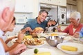 Multi-Generation Family Sitting Around Table Eating Meal Royalty Free Stock Photo