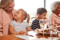 Multi-Generation Family Sitting Around Table Enjoying Meal At Home Together Royalty Free Stock Photo