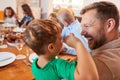 Multi-Generation Family Sitting Around Table Enjoying Meal At Home Together Royalty Free Stock Photo