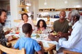 Multi-Generation Family Sitting Around Table At Home Enjoying Meal Together Royalty Free Stock Photo