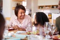 Multi-Generation Family Sitting Around Table At Home Enjoying Meal Together Royalty Free Stock Photo